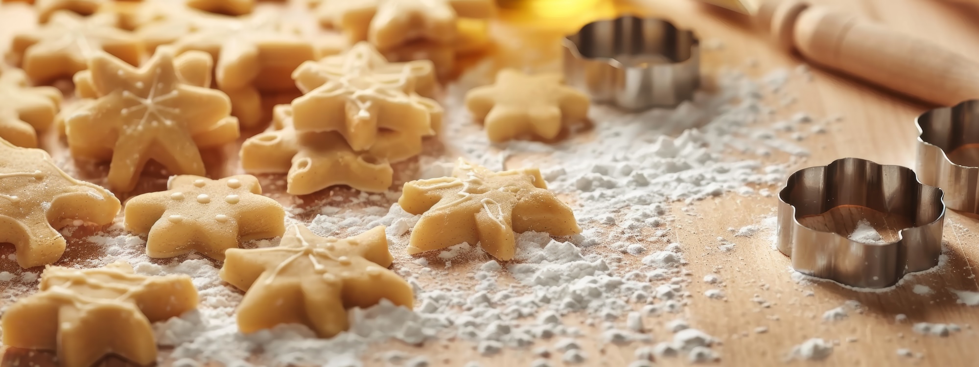 Bright and minimalistic cookie cutters and dough on clean and light white background